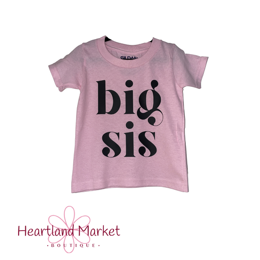 Pale pink toddler t-shirt with text "Big sis" in lowercase girly lettering. 